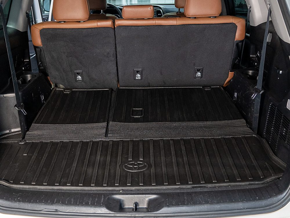 The same Toyota Highlander cargo area after detailing, with a clean rubber mat, clean seat backs, and a clean rear sill