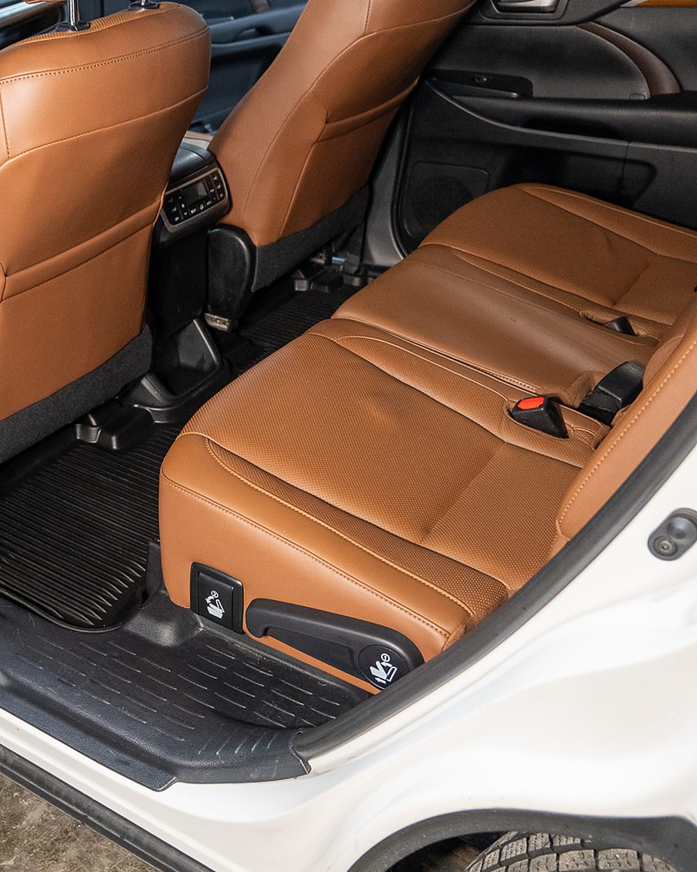 The same Toyota Highlander second row after detailing, with the tan leather cleaned and conditioned and the rear floor mat washed