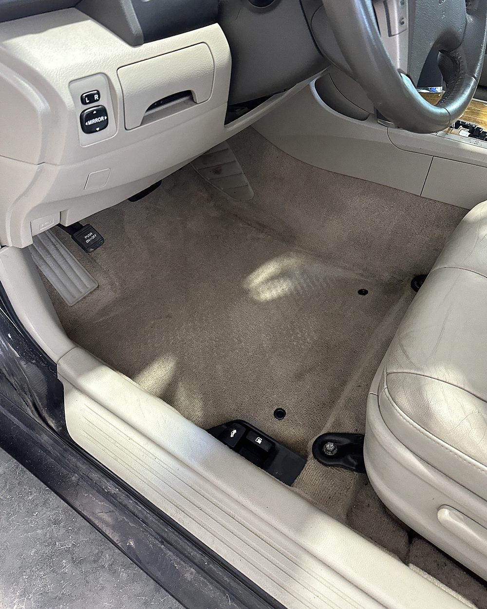 The same sedan footwell after detailing, the beige carpet back to an even colour with the door sill and seat base wiped clean
